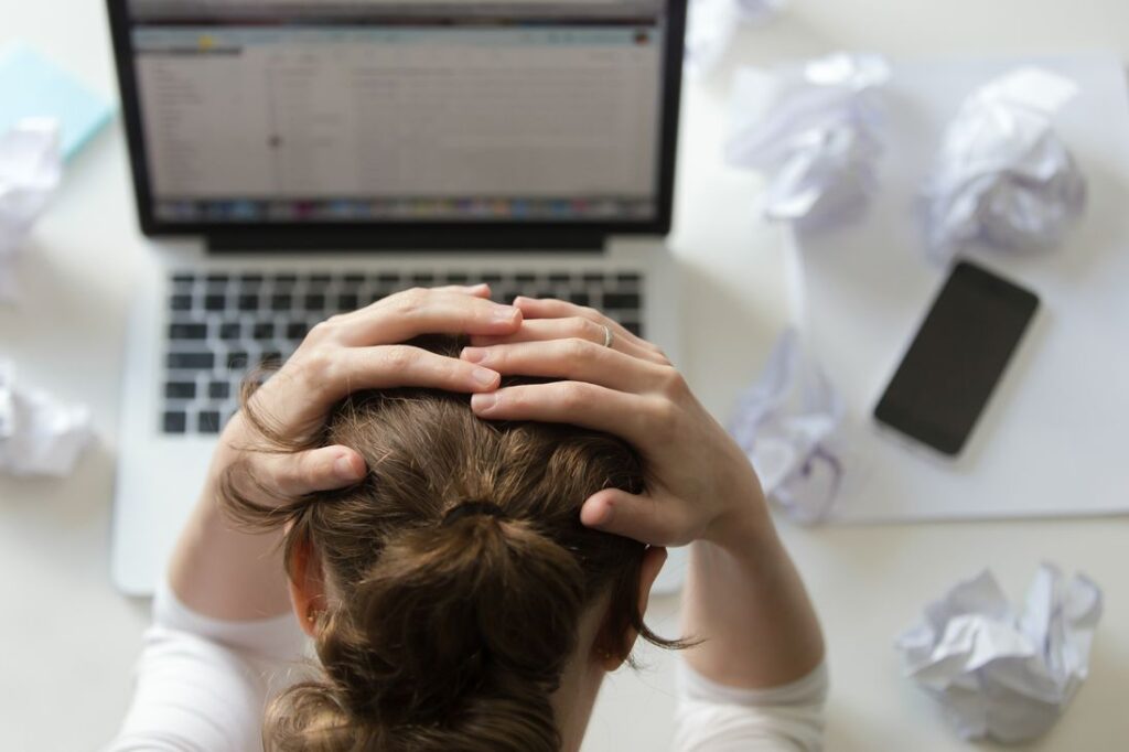 portrait d une femme qui saisit la tete au bureau pres de l ordinateur portable freepik