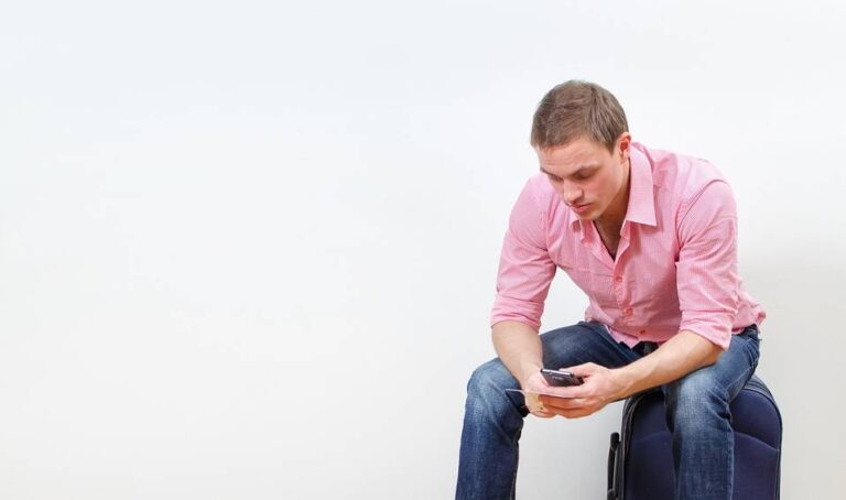 Homme seul assis sur une valiseDepositphotos 21479467 S