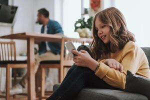 fille smartphone pere au loin