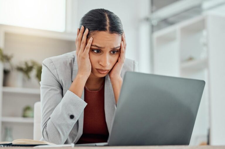 Femme qui se tient la tete entre les mains devant son ordinateur Depositphotos 600174090 S